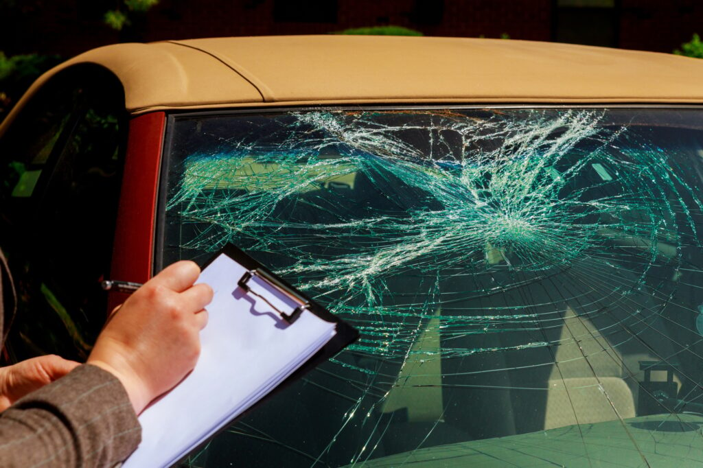 Insurance agent writing report on clipboard after car accident